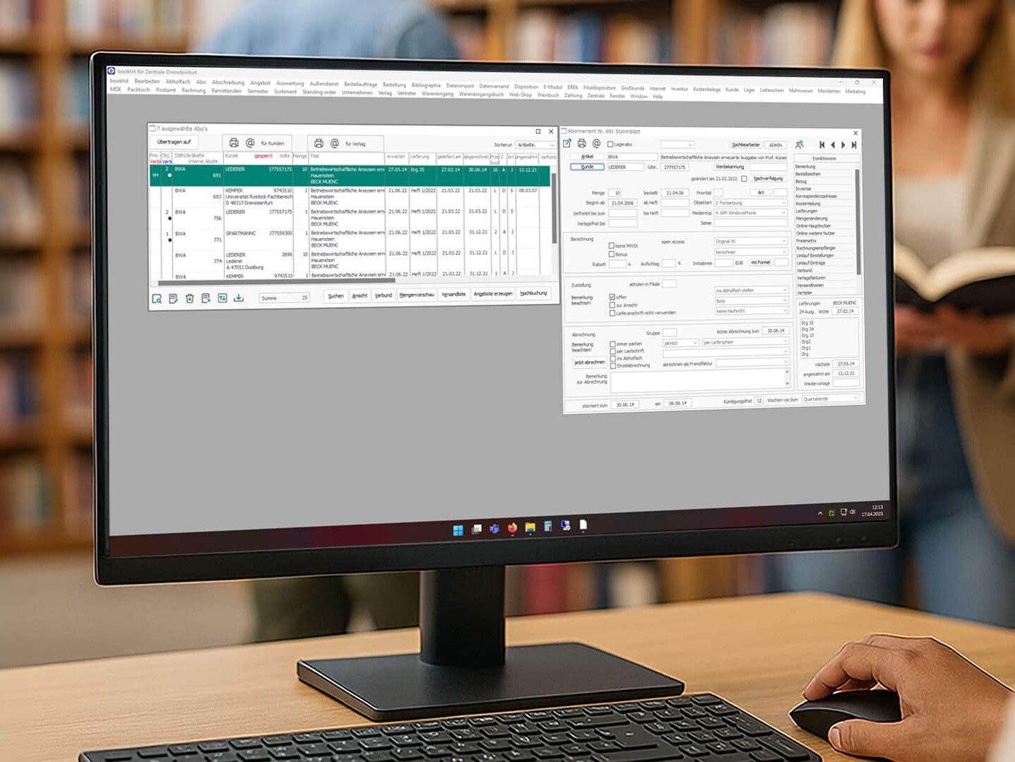 Monitor mit GRÜN bookhit Software in einer Buchhandlung, seitlicher Blickwinkel, mit Tastatur und Maus.